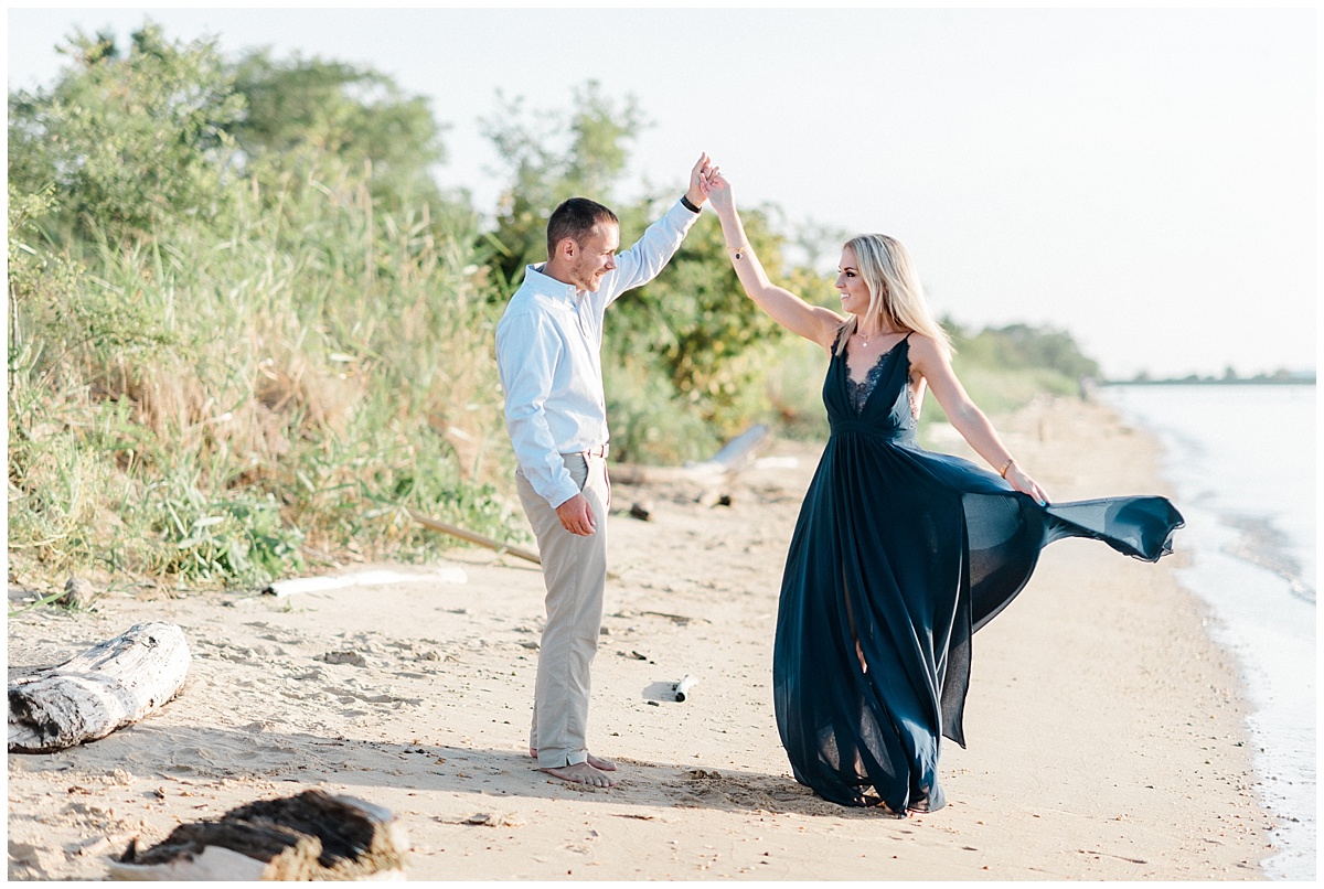 A Coastal engagement photo featuring a flowy navy blue dress and a grassy beach at Terrapin Park in Stevensville, Maryland by Annapolis Photographer Megan Bennett Photography